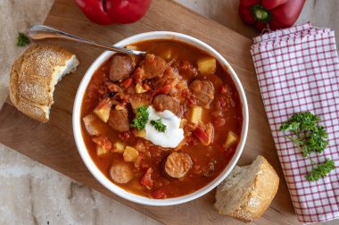 Lezzetli ev yapımı lahana turşusu çorbası içinde dolmalık biber, patates, domates ve krakauer sosis.