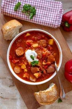 Lezzetli ev yapımı lahana turşusu çorbası içinde dolmalık biber, patates, domates ve krakauer sosis.