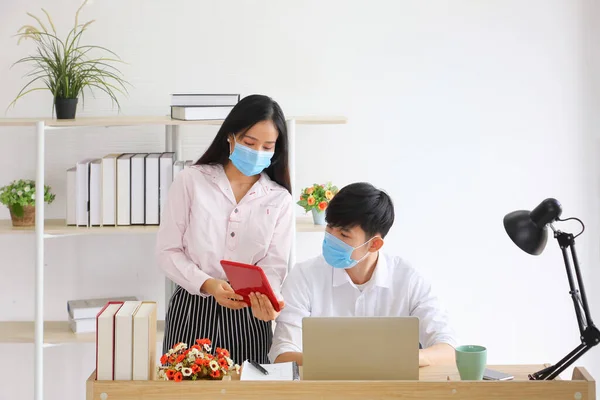Employees working from home office while wearing medical face mask for social distancing in new normal situation for protecting and preventing the infection of corona virus or covid-19