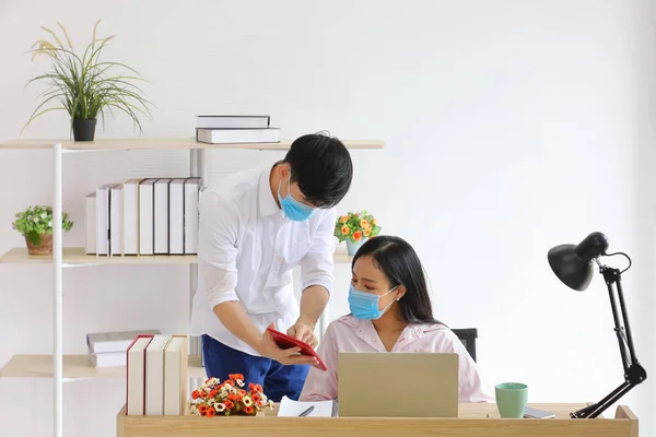 Employees working from home office reopening while wearing medical face mask for social distancing in new normal situation for protecting and preventing the infection of corona virus or covid-19