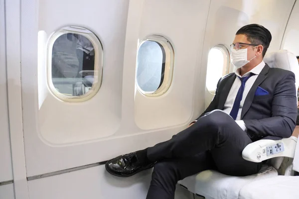 사업가는 마스크를 착용하고 비행기 편안하게 얼굴을 — 스톡 사진