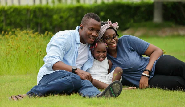 Familia Afroamericanos Con Una Pequeña Hija Sentada Hierba Verde Mientras —  Fotos de Stock