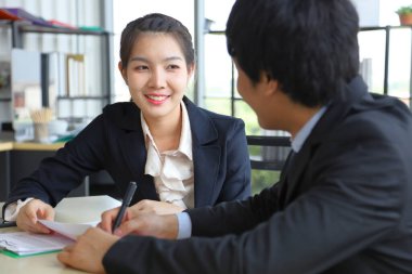 Ekonomik krizden sonra modern ofis içinde yıllık satış raporunu tartışan Asyalı iş kadını. 