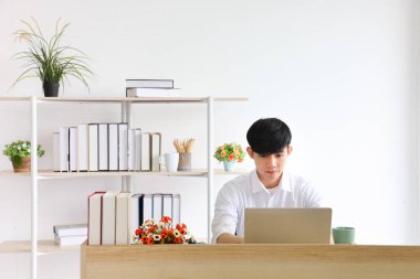 İş yerindeki sosyal uzaklık politikası çerçevesinde çalışan erkek çalışanlar fotokopi alanı ile normal yaşam tarzlarını değiştirirken yalnız çalışırlar.