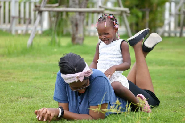 Madre Hija Afroamericanas Disfrutan Pasar Tiempo Juntas Tumbadas Hierba Del —  Fotos de Stock