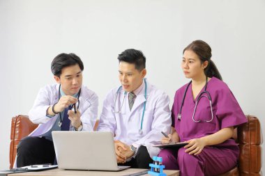 Bir grup doktor, toplantı odasındaki hastalara kan örneği ve bakım planı tanısı için fikir alışverişinde bulunarak beyin fırtınası yapıyorlar.