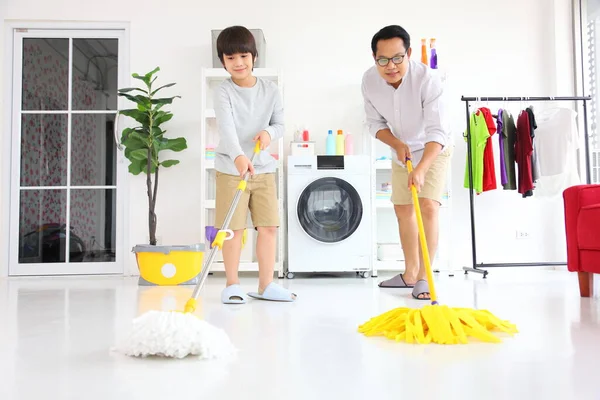 아시아의 아버지와아 일상적 허드렛일 개념을 걸레와 사용하여 바닥을 청소하는 돕는다 — 스톡 사진