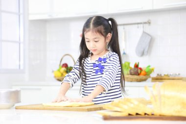 Genç Asyalı kız hamur yoğurarak modern mutfakta pişirme ve pişirme konseptinde hamur işi yapıyor.