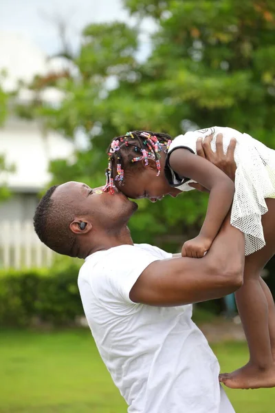 Afroamerykanin Ojciec Podnosząc Swoją Córeczkę Pocałować Czoło Zewnątrz Ogrodzie Dla — Zdjęcie stockowe