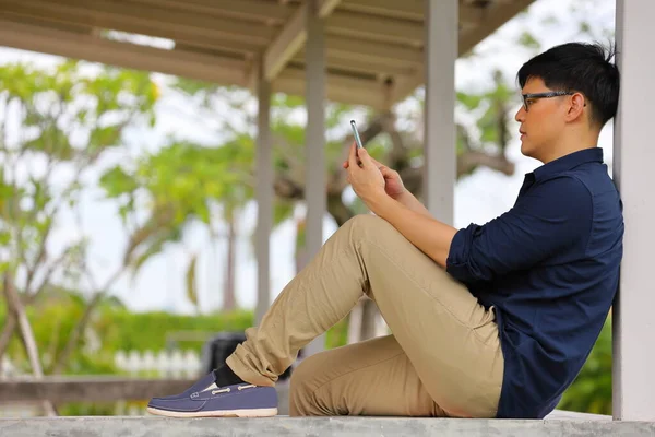 Evinden Çalışan Asyalı Işadamı Verandada Rahatça Otururken Akıllı Telefon Kullanıyor — Stok fotoğraf