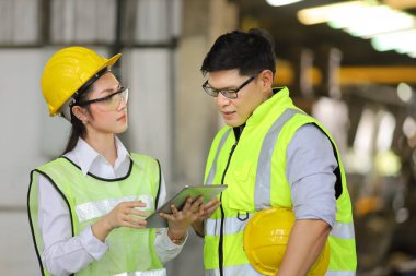 Mühendislerden oluşan tam güvenlik ekipmanları ağır sanayi fabrikasında çalışıyor ve teftiş ediyor.