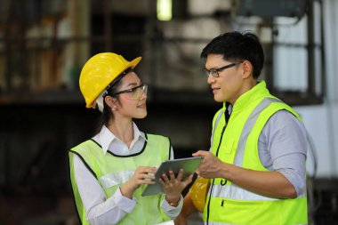 Mühendislerden oluşan tam güvenlik ekipmanları ağır sanayi fabrikasında çalışıyor ve teftiş ediyor.
