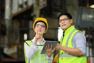 Mühendislerden oluşan tam güvenlik ekipmanları ağır sanayi fabrikasında çalışıyor ve teftiş ediyor.