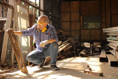 Usta Asyalı marangoz, emeklilik yaşında kendi garajındaki ahşap çerçeveyi fotokopi alanı olan bir hobi için tamir ediyor.