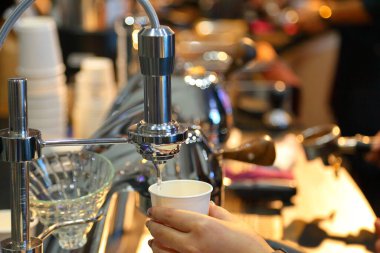 Barista sabahları espresso makinesiyle uzun siyah ya da Americano kahvesi hazırlıyor.