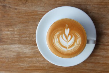 Lale desenli kahve sanatının en üst görüntüsü. Kırsal ahşap masa çubuğunda üzerinde fotokopi alanı olan lale desenli.