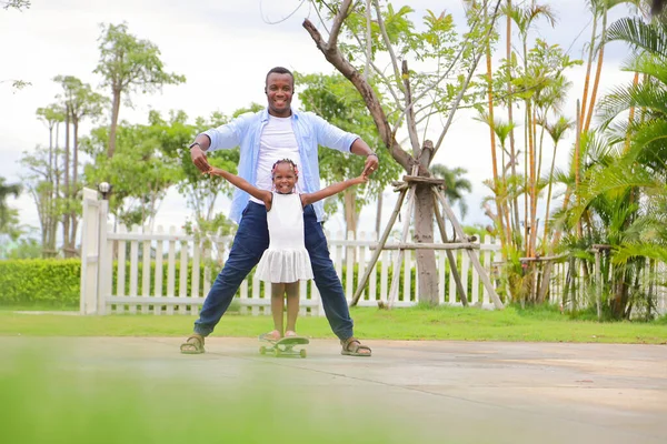 Afroamerykanin Ojciec Uczy Swoją Córeczkę Grać Deskorolce Parku Czasie Lata — Zdjęcie stockowe