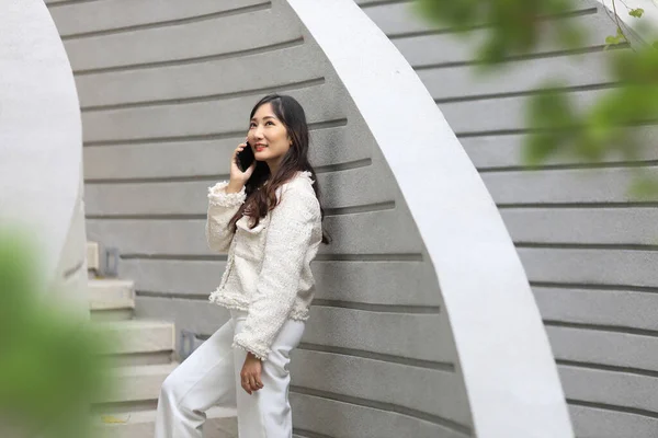 Mulher Asiática Usando Telefone Celular Enquanto Caminha Longo Edifício Moderno — Fotografia de Stock