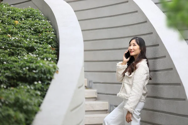Mulher Asiática Usando Telefone Celular Enquanto Caminha Longo Edifício Moderno — Fotografia de Stock