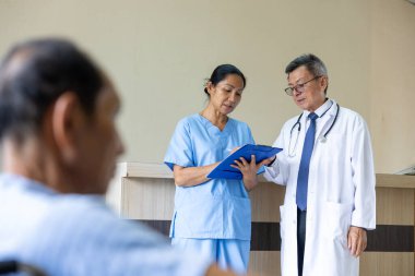 Asyalı doktor ve hemşirelerden oluşan bir ekip deneyimli uzman hekim doktorla hastanın tıbbi kayıtları üzerine tartışıyor ve beyin fırtınası yapıyor.