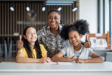Afrikalı öğretmen, akademik okuryazarlık ve eğitim kullanımı için deneyim ve internetten gelen bilgileri kullanarak sınıftaki genç öğrencilere ders veriyor ve onlara rehberlik ediyor.