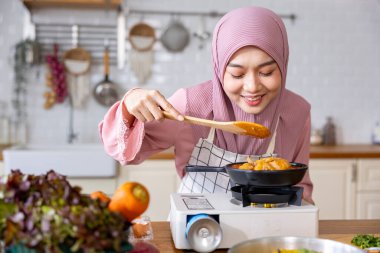 Mutlu Arap Müslüman ev hanımı, Orta Doğu 'da lezzetli helal yemekler ve Ramazan ayından sonra bayram ziyafeti için İran mutfağında yemek hazırlıyor.