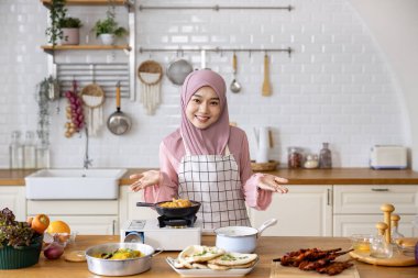 Mutlu Arap Müslüman ev hanımı, Orta Doğu 'da lezzetli helal yemekler ve Ramazan ayından sonra bayram ziyafeti için İran mutfağında yemek hazırlıyor.