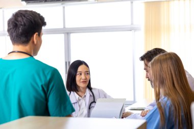 Çeşitlilik doktoru ve hemşire, deneyimli kıdemli hekim uzmanlarıyla ilgili kesin tedavi planı üzerine hasta kayıtları üzerinde tartışıyor ve beyin fırtınası yapıyorlar.