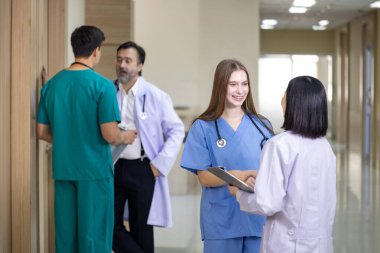 Çeşitlilik doktoru ve hemşire, deneyimli kıdemli hekim uzmanlarıyla ilgili kesin tedavi planı üzerine hasta kayıtları üzerinde tartışıyor ve beyin fırtınası yapıyorlar.