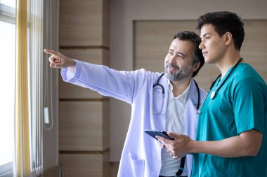 Kıdemli doktor, genç hemşireyle fütüristik ve modern teknolojiyi tartışıyor ve beyin fırtınası yapıyor.