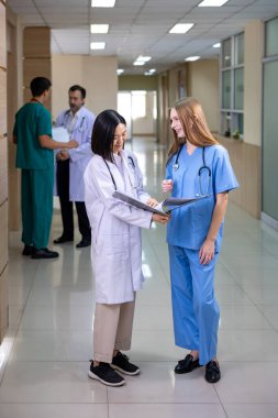 Kıdemli doktor, deneyimli bir hekim olan Hekimlerin kesin tedavi planı için genç hemşireyle hasta kayıtları üzerinde tartışıyor ve beyin fırtınası yapıyor.