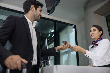 Kafkasyalı işadamı uçak pistine inmeden önce son bir teftiş için havaalanı personelinden uçuş kartı alıyor.