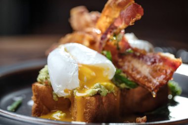 İki porsiyon Benedict usulü yumurta, kıtır jambon, haşlanmış yumurta ve kırsal kahverengi tabakta Hollandez sosu.