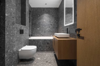 Modern minimalist banyo koyu iç tasarımı koyu taş fayanslar ve ahşap mobilyalar.