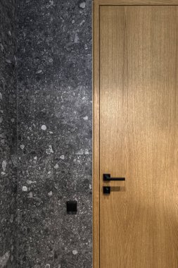 Modern minimalist banyo koyu iç tasarımı koyu taş fayanslar ve ahşap kapılı.