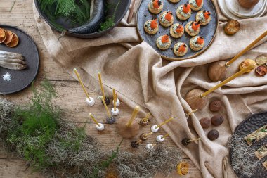 El yapımı el yapımı el yapımı tabakları ve keten masa örtüsü üzerinde çiğ balıklar ve toprak tonlarında ahşap aksesuarlar.