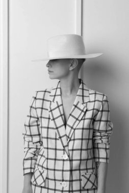 Zarif, karizmatik, sarışın ve kısa saçlı güzel geniş gülüşlü, büyük beden keten takım elbiseli, stüdyoda soyutlanmış poz veren kadınlar. Siyah ve beyaz versio