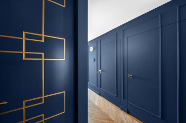 Modern iç dekorasyonda mavi klasik duvar dekoru altın çizgili dekorlar, ahşap zemin, gizli kapılar.