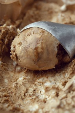 Kahveli dondurmalı gümüş kepçe. Dondurma kahverengi desen arkaplanı.