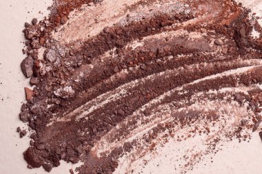 Göz farı kırılmış. Bej arkaplanda makro makyaj dokusu