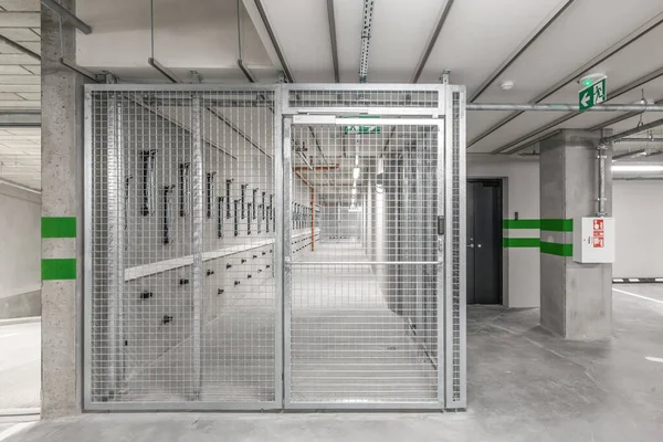 Empty public underground parking lot or garage interior with concrete stripe painted columns and signs