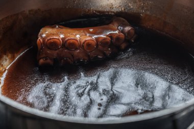 Gümüş tencerede pişirilmiş ahtapot bacağı.