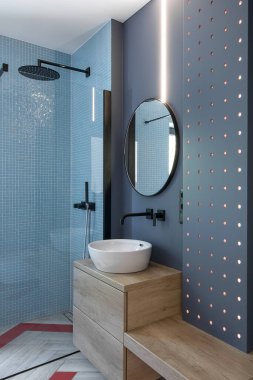 Lacivert duvarları ve ahşap mobilyaları olan modern minimalist banyonun iç mimarisi.