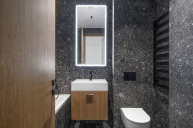 Modern minimalist banyo koyu iç tasarımı koyu taş fayanslar ve ahşap mobilyalar.
