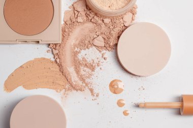 Çökmüş bej rengi yüz bitirme, bronzlaştırma ve sıvı serum tozu ve beyaz arka grupta izole edilmiş araçlarla ayarlandı