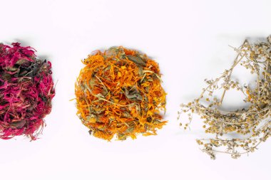 Beyaz arka planda kurutulmuş gevşetici çay otları var. Calendula, monarda didyma, pelin otu