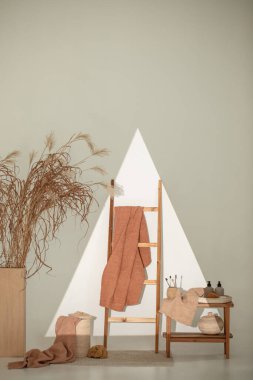 Doğal waffle keten havluları ahşap bankta toprak tonları ve bambu diş fırçaları, rattan sepetleri ve sabun makinesiyle havlu merdiveni. Günlük vücut bakımı, spa ve sıhhat sıfır atık tuvalet kavramı 