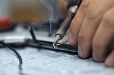 Kablolar lehim demiriyle birleştiriliyor. Levye ucu üzerinde lehim kablosu eritiliyor
