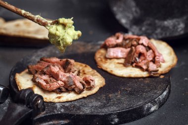 El yapımı guacamole ile ızgara biftekli taco pişirme işlemi.