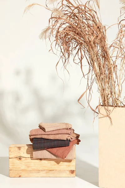 Doğal waffle keten havluları ahşap bankta toprak tonları ve bambu diş fırçaları, rattan sepetleri ve sabun makinesiyle havlu merdiveni. Günlük vücut bakımı, spa ve sıhhat sıfır atık tuvalet kavramı 